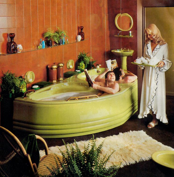 a man and woman in a green bathtub with plants on the floor next to it