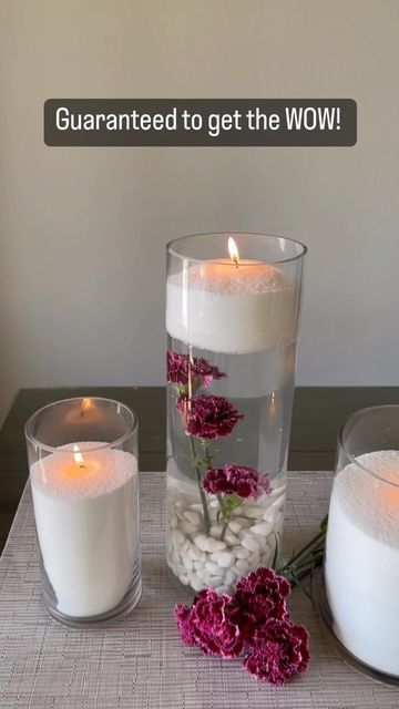 three candles are sitting on a table with flowers