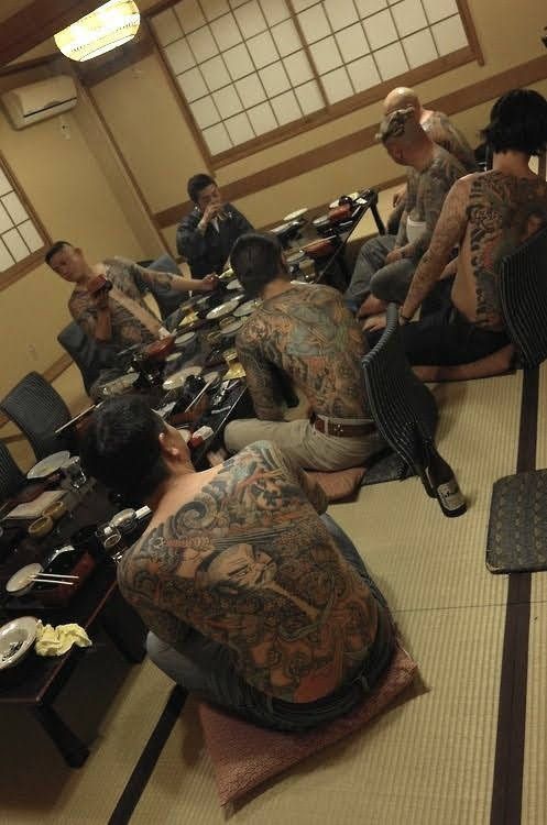 several men with tattoos sitting on the floor