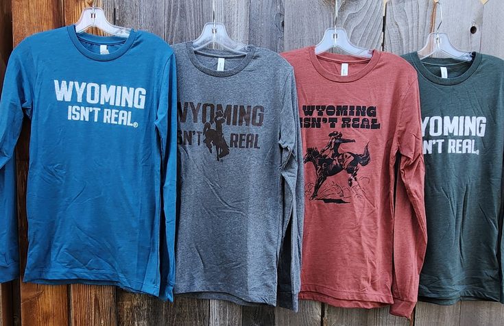 This Bella+Canvas classic unisex jersey T-shirt fits like a well-loved favorite. A classic crew neck with long sleeves and ribbed cuff and neck. A semi-relaxed fit made of 52% cotton, 48% poly. Several colors and sizes to choose from. Wyoming Isn't Real logo that means Wyoming is too good to be true!! Relaxed Fit T-shirt With Ribbed Cuffs For Fall, Casual Long Sleeve T-shirt, Comfortable Long Sleeve Tops With Text Print, Comfortable Long Sleeve T-shirt With Text Print, Fall Crew Neck Screen Print Tops, Screen Print Crew Top For Fall, Tri-blend Crew Neck Top For Fall, Unisex Letter Print Tops For Fall, Crew Neck Top With Text Print For Fall