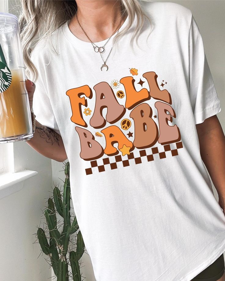 Fall Season is upon us and this cute fall babe shirt will get you in the mood! The retro design is super cute and unqiue, everyone will be obsessed and asking where you got your shirt.  THE MATERIAL: Classic unisex jersey short sleeve tee fits like a well-loved favorite.  Soft cotton and quality print.  The shoulders have taping for better fit over time.  Dual side seams hold the garment's shape for longer. 100% Airlume combed and ringspun cotton (fiber content may vary for different colors) Runs true to size Sizing: Unisex sizing (Looser fit for women) If you're looking for more of a tighter fit size down, oversize fit size up. We do not issue refunds or accept returns due to incorrect sizing, so please double-check the size before purchase. *The placement of the graphic may vary slightly Vintage Slogan T-shirt For Fall, Cute White Fall Shirt, Cute White Shirt For Fall, White Tops With Funny Text For Fall, Retro Graphic Print Tops For Fall, Fun Fall Top With Letter Print, Trendy Fall Slogan Tops, Trendy Fall Shirt With Text Print, Retro Tops With Funny Print For Fall