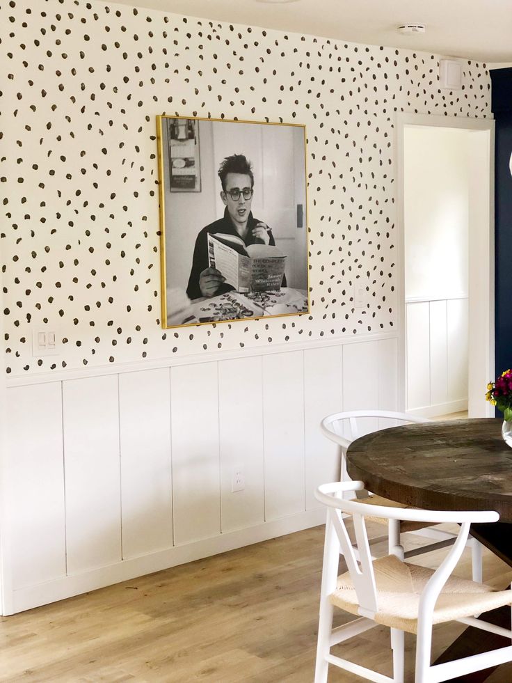 a dining room table with two chairs and a framed photo on the wall above it