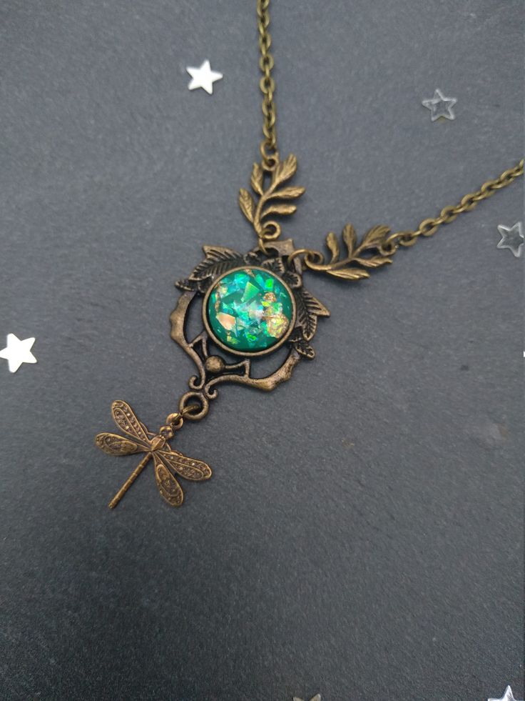 PLEASE read my shop announcement before placing an order so you know what to expect right now. Plus, when ordering from outside Europe, don't forget to provide a phone number for the courier to ensure the fastest and smoothest delivery. Heart of the forest green opal dragonfly necklace. Woodland / Art Nouveau... A statement yet dainty piece. The affordable alternative to real opal in a high quality and beauty green resin opal ornated with golden foil accents. This is a short necklace, about 15 / Magical Metal Necklaces For Gifts, Elegant Green Dragonfly Shaped Jewelry, Fairycore Clavicle Necklace As A Gift, Fairycore Pendant Jewelry For Gifts, Fairycore Clavicle Chain Necklace As Gift, Fairycore Metal Necklaces As Gift, Handmade Magical Style Green Jewelry, Fairycore Style Metal Necklaces For Gifts, Fairycore Metal Necklaces For Gift