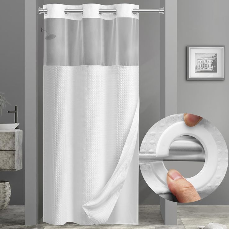 a bathroom with a white shower curtain next to a hand holding a toilet paper roll