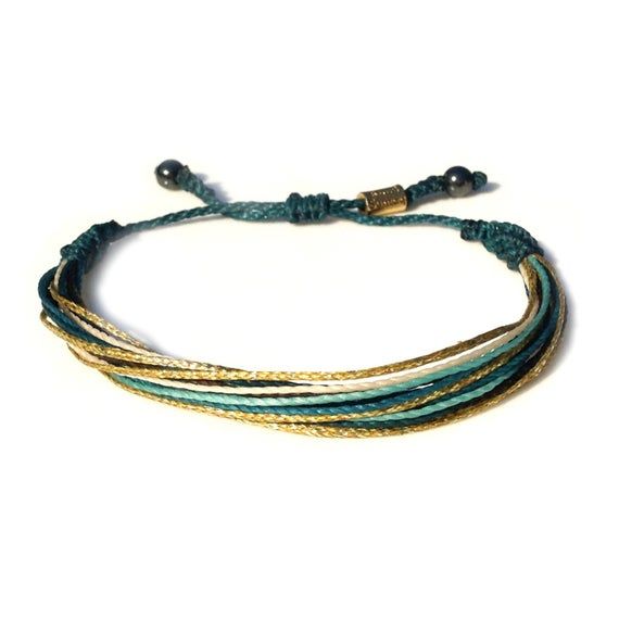 EMERALD GREEN AND GOLD STRING BRACELET:This hand-knotted, multi-strand string bracelet includes two genuine Hematite stones and a Rumi Sumaq logo bead. In beautiful boho shades of emerald green, metallic gold, aqua and brown it is the perfect festival or Christmas bracelet.  Or you may think of this string bracelet as a sophisticated and grown up friendship bracelet. Buy one for yourself and another for your best friend. Or make it a sister's bracelet by purchasing one for each of your sisters. Resizable Gold Wrap Bracelet As Gift, Gold Multi-strand Wrap Bracelet For Gift, Adjustable Gold Wrap Bracelet For The Beach, Green Multi-strand Beaded Bracelets Gift, Green Multi-strand Wrap Bracelet As Gift, Adjustable Multicolor Jewelry For Holiday, Gold Hand Wrapped Friendship Bracelets As Gift, Green Adjustable Wrap Bracelet As Gift, Adjustable Gold Braided Bracelet Hand Wrapped