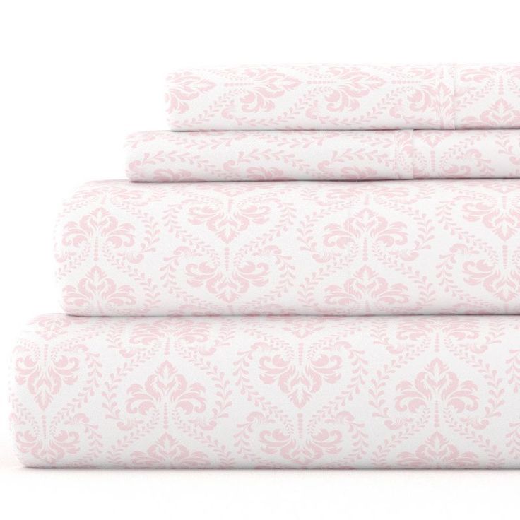 four sheets in pink and white with floral designs on the bottom one is folded up