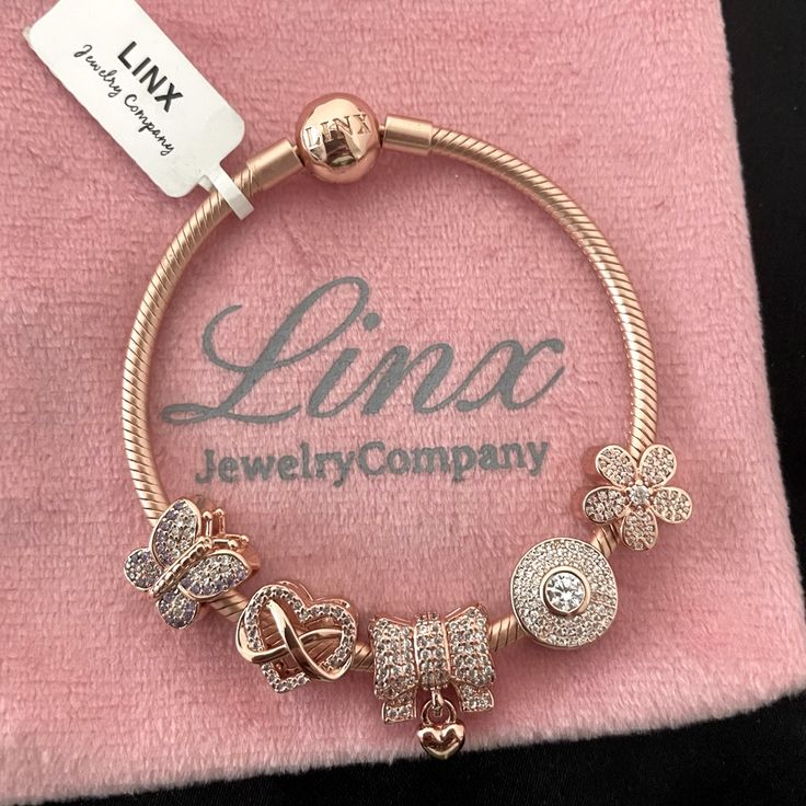 Linx Snake Chain Style Charm Bracelet In 18k Rose Gold Over 925 Sterling Silver, With A Ball Clasp. The Bracelet Is 3mm In Width And Available In Multiple Lengths, Including Child Size. This Bracelet Comes With 5 Linx Charms In 18k Rose Gold Over 925 Sterling Silver Charms. All Items Are New And Come In A Luxury Velvet Jewelry Pouch. *Bracelet And Charms Are Superior Quality. Rose Gold Bracelets With Diamond Accents As Gift, Rose Gold Round Bracelets With Charms, Luxury Rose Gold Jewelry With Sparkling Stones, Luxury Rose Gold Bracelets With Sparkling Stones, Rose Gold Plated Bracelets, Elegant Pink Gold Charm Bracelet As Gift, Elegant Pink Gold Charm Bracelet Gift, Elegant Rose Gold Bracelets With Charms, Luxury Rose Gold Jewelry With Charms