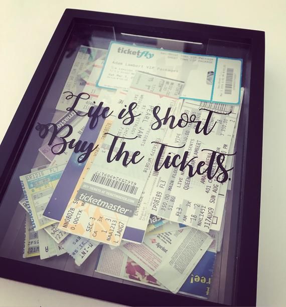 there is a black frame with some tickets and words on it that says life's short buy the tickets