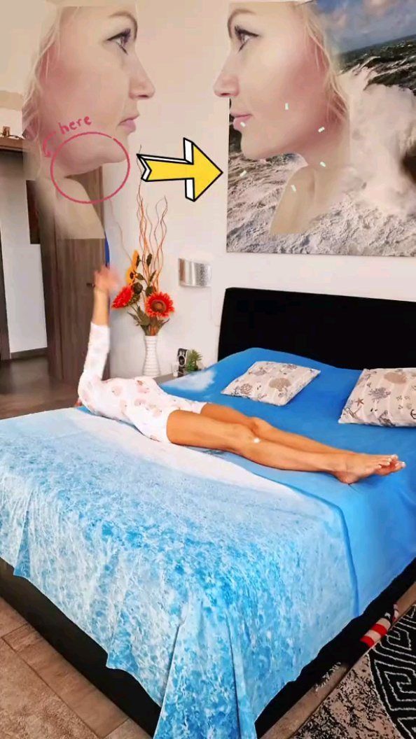 a woman laying on top of a blue bed in a bedroom next to a painting