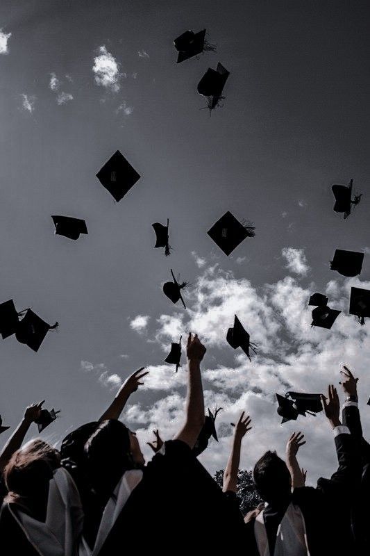 a group of graduates throwing their caps in the air