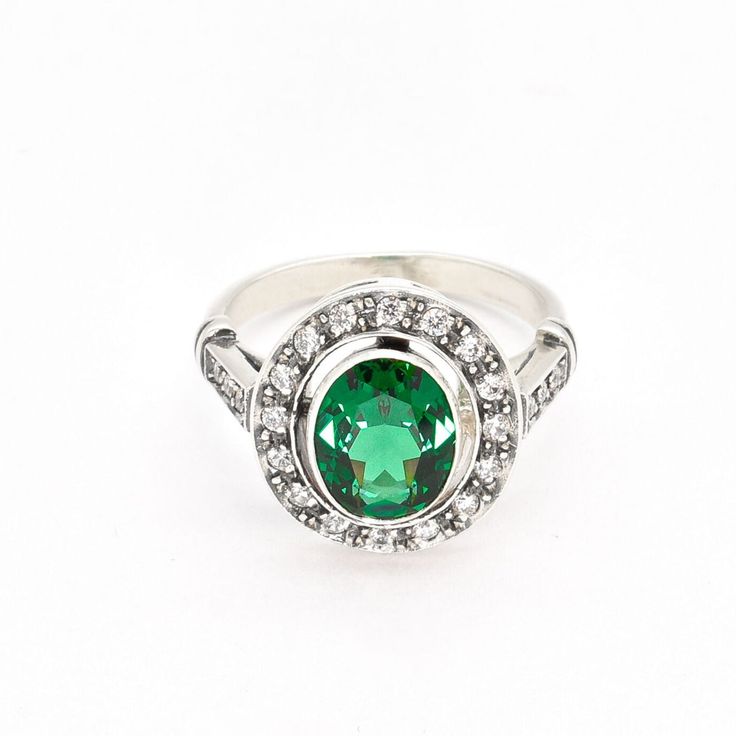 Vintage Emerald Ring set with a Created Emerald in a perfect diamond cut, flawless clarity, at 10x8mm (3 Cts) surrounded by CZ Diamonds. Solid 925 Sterling Silver ☞ made to last.Click here for ☞ Matching PendantClick here for ☞ Matching EarringsDetails:• Created Emerald in a flawless clarity & CZ Diamonds• Emerald: 10x8mm, 3 Cts, diamond cut• Dimensions: Band width ≈ 2.4mm, thickness ≈ 1mm• Solid 925 Sterling SilverSKU 2268 Luxury Sterling Silver Emerald Ring With Halo Setting, Oval Emerald Ring With Center Stone For Formal Occasions, Formal Oval Emerald Ring With Center Stone, Dazzling Oval Cluster Ring With Vvs Clarity, Dazzling Oval Emerald Ring With Brilliant Cut, Classic Oval Cabochon Jewelry With Brilliant Cut, Classic Oval Cluster Ring With Halo Design, Oval Emerald Ring With Halo Setting For Formal Occasions, Timeless Oval Gemstone Halo Ring