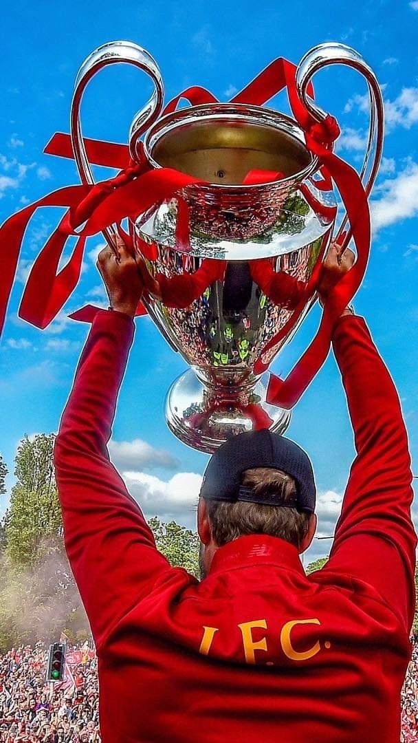 a man holding up a trophy in front of a crowd