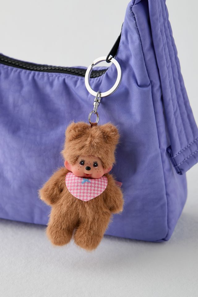 a teddy bear keychain hanging from a purple purse