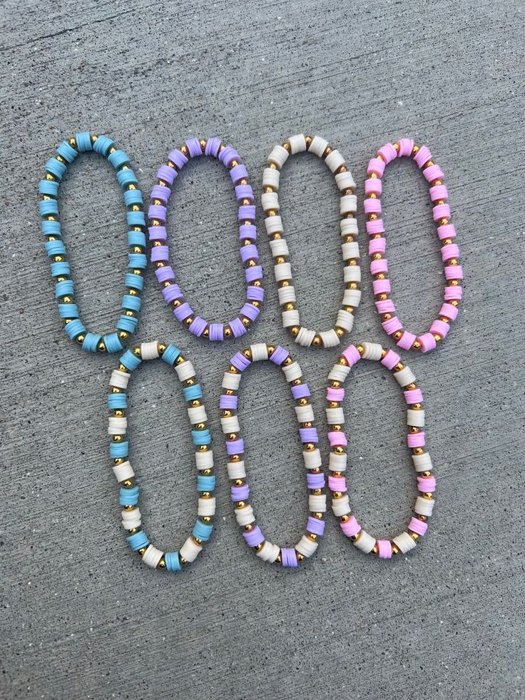 four beads are laid out in the shape of the word boooo on a concrete surface