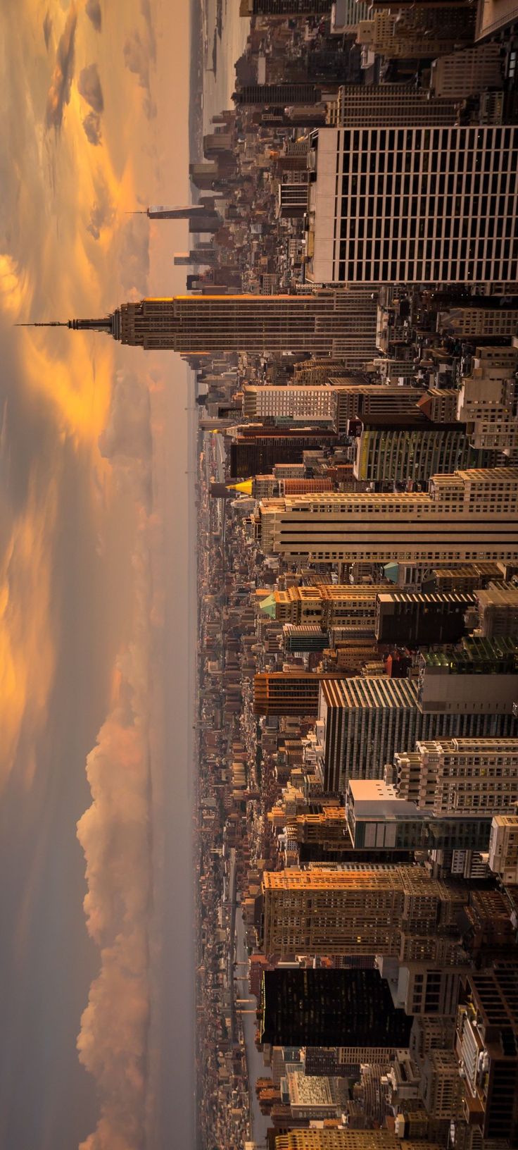 an aerial view of new york city with clouds in the sky and skyscrapers on either side