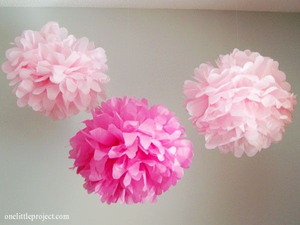 three pink tissue pom - poms hanging from the ceiling