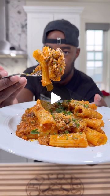 the man is eating pasta from his plate