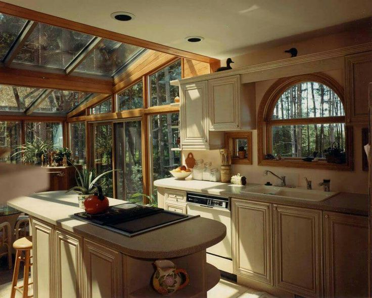 a kitchen filled with lots of windows next to a stove top oven and counter top