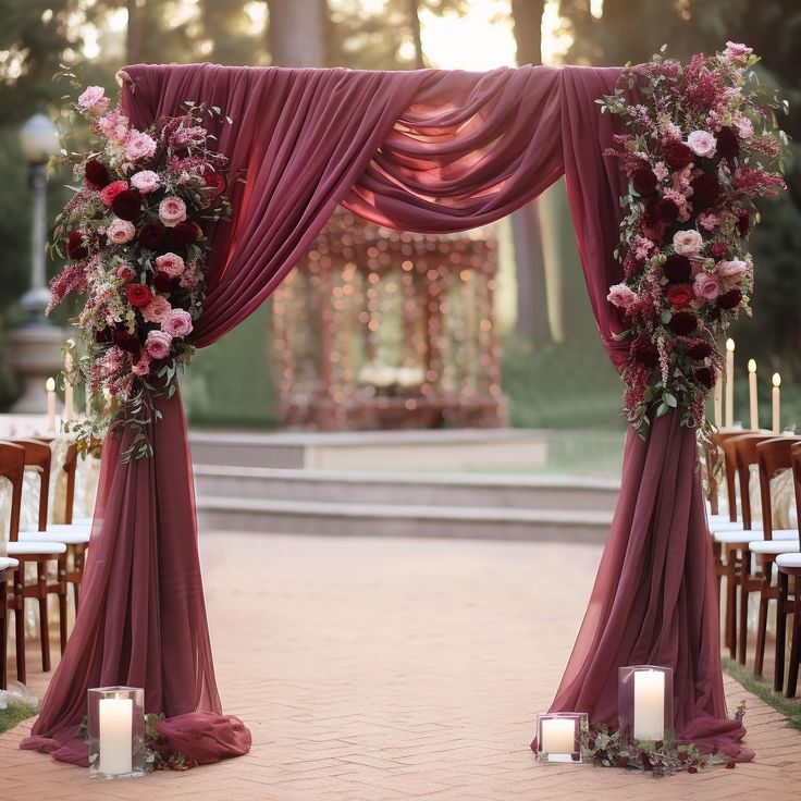 an outdoor ceremony set up with purple drapes and pink flowers on the altars