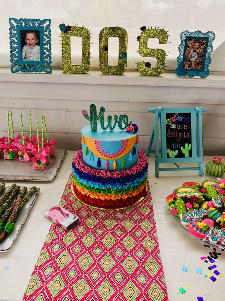 there is a colorful cake on the table with other decorations and decor items around it