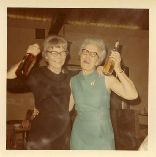 an old photo of two women holding up bottles