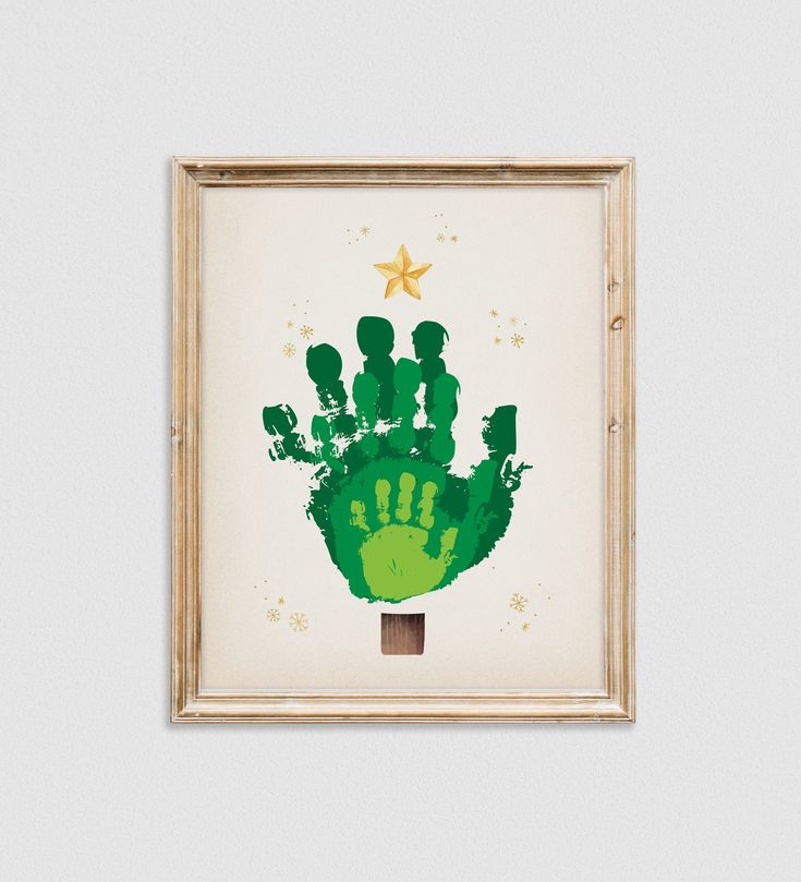 a green hand print on a white wall above a wooden frame with a gold star