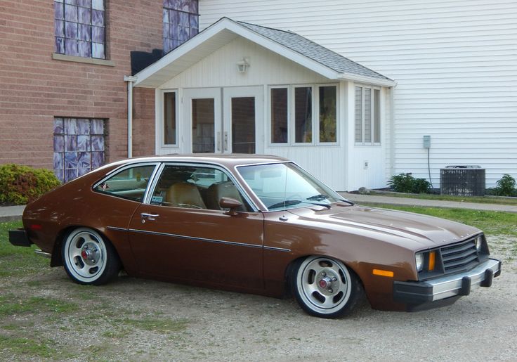 a brown car parked in front of a house