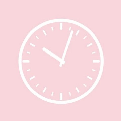 a white clock on a pink background