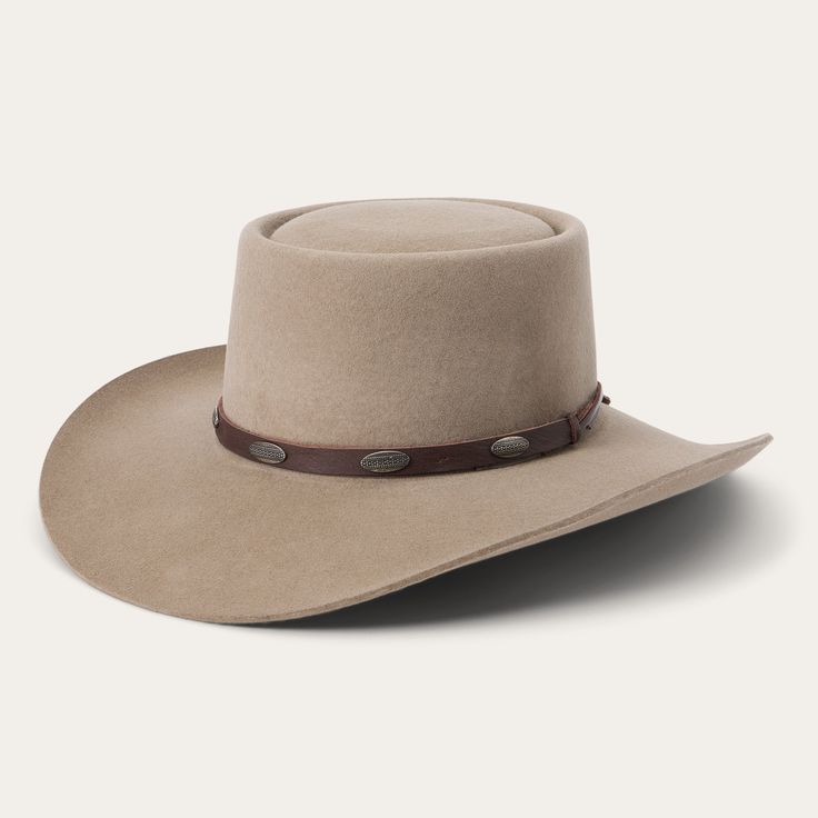 This western-inspired fashion hat brings a welcome pop of Cowboy Core to any look. Its bold silhouette features a statement-making 3 1/2" telescope crown, 3 1/2” downturn brim and leather hat band with silver-tone conchos. Handmade in the U.S.A. with a firm finish from high-quality wool felt, it’s finished with a faux leather sweatband and satin liner for a comfortable, all-day fit. 3 1/2" Telescope Crown 3 1/2" Downturn Brim Leather Hat Band With Silver-Tone Conchos Faux Leather Sweatband Satin Cowboy Core, Wild Bunch, Leather Hat, Cut Tees, Denim Boots, Fringe Jacket, Leather Hats, Wool Handmade, Outdoor Men