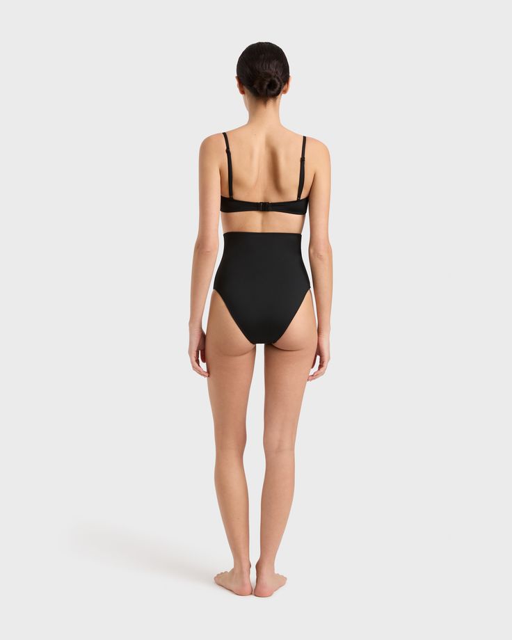 The Lani Bikini Bottom in Black is super high waisted and flattering. Self-lined in our luxuriously soft Embodee™ fabric, Lani offers regular bottom coverage, a high cut leg line and soft edges for supreme comfort. Fabric sustainably made in Italy. Garment sustainably and ethically made in Australia High Waist Smoothing Shapewear For Summer, High-waist Smoothing Shapewear For Summer, Chic Black Swimwear With Moderate Back Coverage, Black High Waist Swimwear With Built-in Bra, Black High-waist Swimwear With Built-in Bra, High Waist Black Swimwear With Built-in Bra, Black Seamless Shapewear Swimwear, Chic Black Smoothing Swimwear, Black Compressive Swimwear With Lined Body