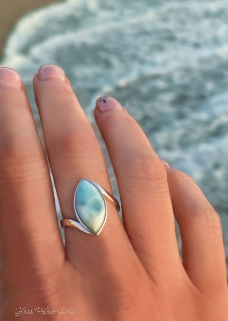 Natural Larimar Marquise ring in 925 Sterling Silver.Beautiful rare blue Larimar is a gemstone found exclusively in the Caribbean.- Hammered 925 Sterling Silver band.- Bezel set cabochon Larimar stone measures 18mm.- Sustainably made in California USA. *A B O U T L A R I M A R*- A native Dominican first found larimar on the beach, where it had washed down from the mountains. They named the gemstone Larimar, combining the name Larissa (said to be the Dominican islander’s daughter), a young woman Unique Turquoise Larimar Gemstone Ring, Unique Turquoise Larimar Ring, Silver Larimar Jewelry For Healing, Unique Larimar Turquoise Ring As Gift, Larimar Gemstone Jewelry For Anniversary, Unique Larimar Jewelry As A Gift, Gift Larimar Jewelry Stamped 925, Stamped 925 Larimar Jewelry For Gift, Anniversary Larimar Gemstone Jewelry