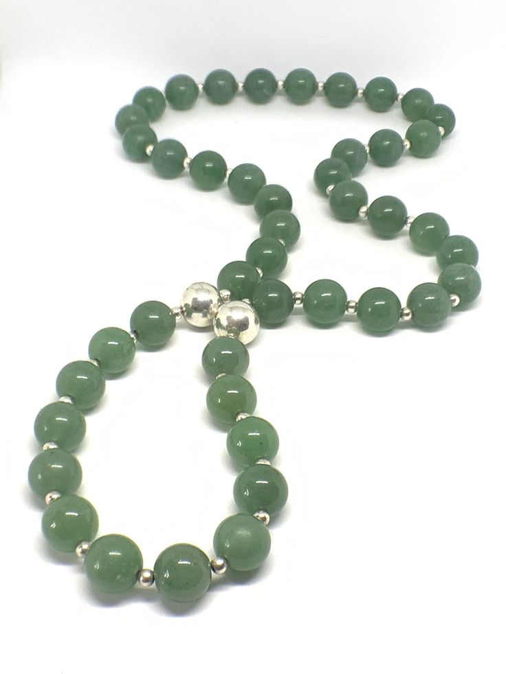 A '70s necklace of Chrysoprase gemstone beads interspersed with smaller silver colored beads. There are two silver colored magnet beads which contrast beautifully with the Kelly green gemstones. A lovely design feature. Chrysoprase is a powerful stone that brings good fortune and prosperity.... Emotionally, Chrysoprase is said to help heal a broken heart by providing a gentle boost to your self-esteem, equalizing emotional balance and fostering acceptance of change and tolerance for others. Chry Hand-strung Green Vintage Beaded Necklaces, Vintage Hand-strung Green Beaded Necklaces, Green Vintage Hand-strung Beaded Necklaces, Green Aventurine Beaded Necklace With Polished Beads, Green Aventurine Round Beaded Necklaces, Green Aventurine Beaded Necklaces, Green Aventurine Round Beaded Necklace, Green Aventurine Bead Necklace, Aventurine Polished Round Bead Necklaces