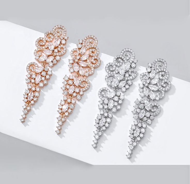 A beautiful pair of bridal earrings that is sure to make a bold statement on your Wedding Day! Adorned with glowing cubic zirconia that capture the light from every angle with a perfectly translucent appeal, the earrings are rhodium/rose gold plated for a bright finish which enhances the intricate detailing and conveys a modern take on old elegance. Length of the earring is 2.4" (approx. 6.1cm); Width: 0.7" (approx. 1.8cm); Weight: 12g. Available in Silver and Rose Gold finishes. To make your ch Cubic Zirconia Bridal Earrings, Exquisite Design, On Your Wedding Day, Bridal Earrings, Rose Gold Plates, Gold Finish, Crystal Rhinestone, Diamond Bracelet, Wedding Jewelry