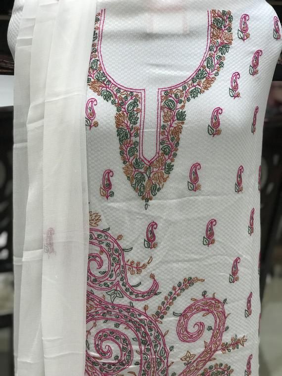 A stunningly marvelous outfit. This outfit features kashmiri sozni (needle) hand embroidery on the neckline with all over booties and on sleeves. The Dupatta features two sided embroidered border with all-over booties.- - - - - - - - - - - - - - - - - - - - Product DetailsCondition: Brand NewF A B R I CShirt: Jacquard GeorgetteDupatta: ChiffonLower: Indian CrepeUnstitchedColor: WhiteCare Instructions: Dry Clean Only✿Subscribe to our Newsletter to get a 20% Discount/Coupon Code in your email Inbo Traditional Embroidered Straight Kurta Dress For Navratri, Traditional Straight Kurta Embroidered Dress For Navratri, Traditional Embroidered Dress Straight Kurta For Navratri, Bollywood Style Sets With Intricate Embroidery On Cambric, Bollywood Style Sets With Intricate Embroidery In Cambric, Bollywood Style Cambric Sets With Intricate Embroidery, Salwar Kameez With Multicolor Resham Embroidery Straight Kurta, White Traditional Embroidered Dress With Zari Work, Straight Kurta Salwar Kameez With Multicolor Resham Embroidery