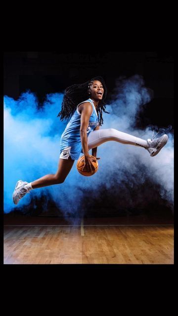 a woman is jumping in the air with a basketball