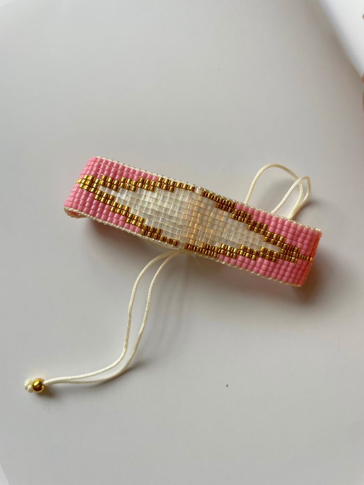 a pink and white beaded object sitting on top of a table