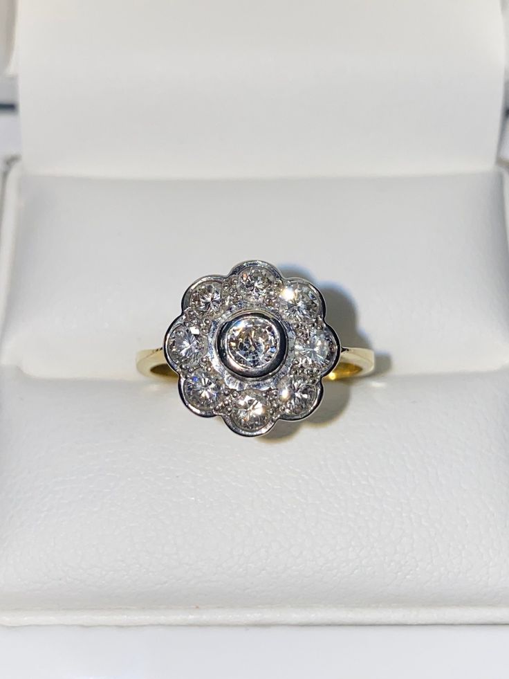 18ct Yellow Gold & Diamond Flower Cluster Ring - 1.00CT  This is a gorgeous ring, A classically designed Diamond Daisy Cluster Ring with nine Brilliant Cut Diamonds set extremely close together to give a fabulous overall appearance when worn. All the Diamonds are very bright and clean and are rim set. The total diamond weight is an impressive 1.00 carat. The ring has very attractive under gallery work which allows lots of light through and the diamonds to sparkle immensely. This ring is set in t Yellow Gold Flower-shaped Diamond Ring, Yellow Gold Flower Diamond Ring With Prong Setting, Elegant Flower Cluster Ring For Anniversary, Classic Jewelry With Brilliant Cut In Flower Shape, Anniversary Flower Diamond Ring With Prong Setting, Classic Flower-shaped Jewelry With Brilliant Cut, Classic Flower Shaped Diamond Promise Ring, Anniversary Flower Diamond Ring With Halo Setting, Flower Shaped Brilliant Cut Jewelry For Wedding And Anniversary