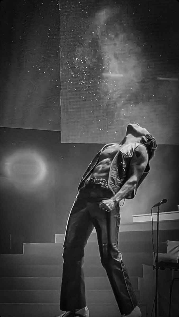 a man standing on top of a stage with his hands in his pockets and head down