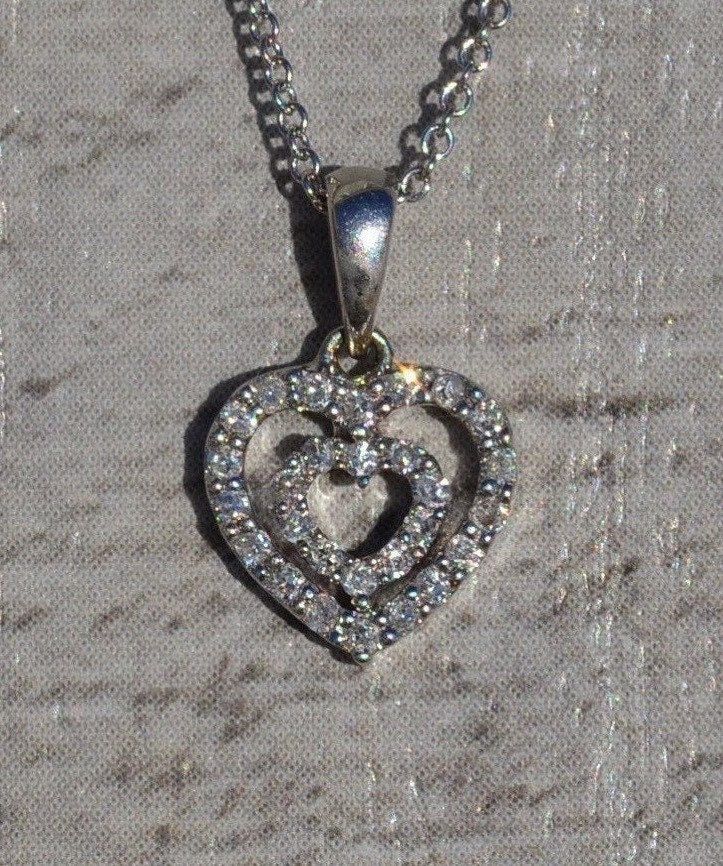 The Emely Ladies 14K Double Heart Diamond Necklace. Crafted in 14 karat white gold, this ladies necklace features a 16 inch chain with a 8.5mm double heart pendant set with diamonds. The perfect necklace to give to that special someone! The chain can be swapped for another length chain (longer or shorter) for an additional charge. Each piece has been hand selected and meticulously identified and graded by a Graduate Gemologist who has been awarded a degree by the Gemological Institute of America Fine Jewelry Double Heart Necklace For Wedding, Double Heart Brilliant Cut Necklace For Wedding, Formal Diamond Necklace With Heart Pendant, Elegant Double Heart Diamond Necklace For Wedding, Wedding Diamond Necklace With Heart Pendant, Wedding White Gold Double Heart Necklace, Formal White Double Heart Necklace, Fine Jewelry Double Heart Diamond Necklace With Charm, Double Heart Brilliant Cut Jewelry For Formal Occasions