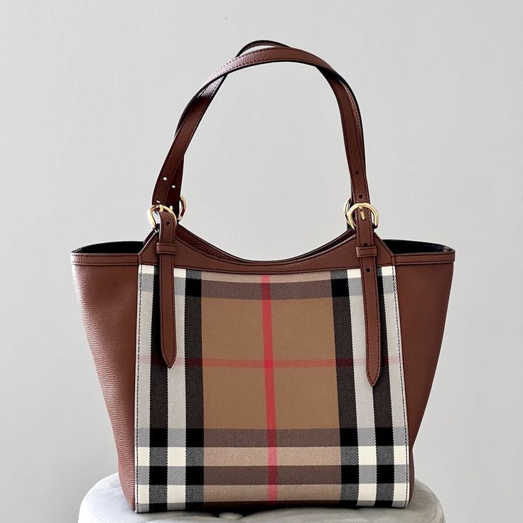 Burberry Canterbury House Check Derby Leather Tote In Tan Cotton Classic Check Panels With Brown Leather Side Panels One Interior Zip Pocket, Two Internal Patch Pockets Metal Feet At Base Black Lining Outer: 100% Cotton Panels/Base/Trim: 100% Calf Grain Leather 10.25x7x10” Made In Italy Nwt And Comes With A Dust Bag Burberry Handbags 2022, Burberry Handbags Burberry, Burberry Check Tote Bag, Burberry Giant Tote, Fake Burberry Handbags, Burberry Catherine Bag, Burberry Fragrance, Louis Vuitton Clutch, Canvas Leather Tote