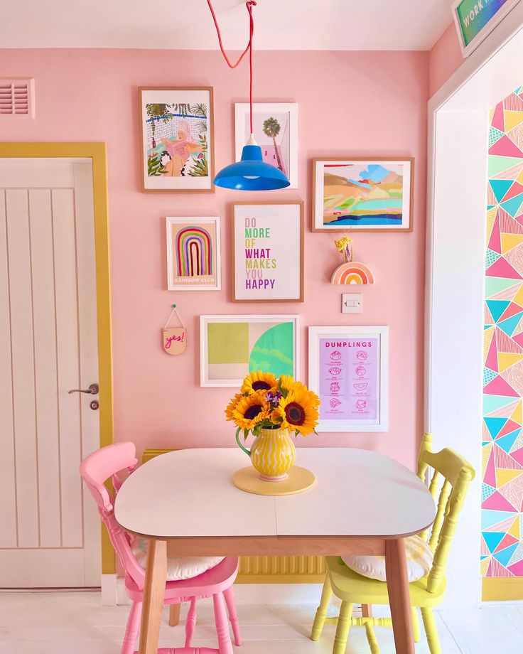 a dining room with pink walls and pictures on the wall