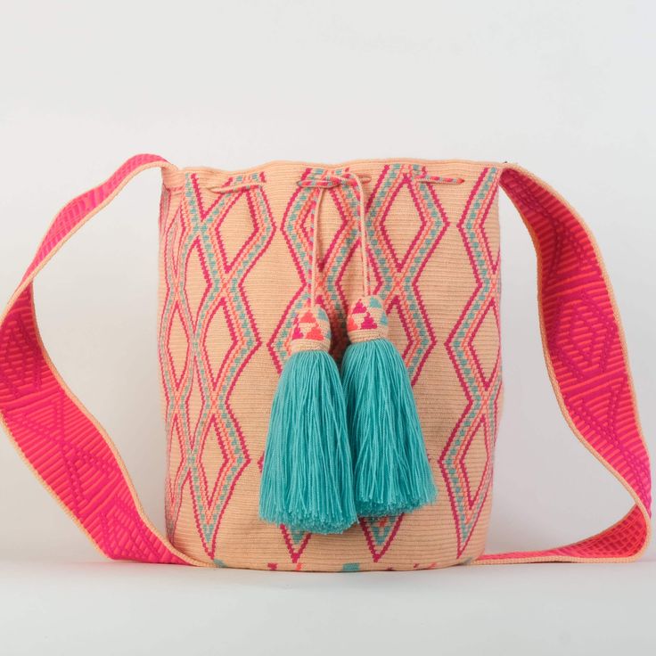 Premium quality, beautifully crafted, one of a kind handmade Wayuu bag. This bag is single thread and takes about 30-35 days to make. The bag size is large and colors are light peach cotton and beautiful noen pink and dark orange combined with a fresh turqoise. It is handcrafted by the Wayuu woman of Colombia,  the largest indigenous group of the country.  This bag specifically is made by master artisan Memella and her team of skilled weavers, known for her amazing detail and quality. They often elaborate these beautiful pieces of art in very hard living conditions. The Wayuu culture is rich in symbolism, tradition and follows a matriarchal society and way of living. These bags are very durable, can be washed on a gentle cycle in washing mashine and tolerate alot of weight. It is made of a Pink Shoulder Bucket Bag As Gift, Pink Rectangular Bucket Bag As Gift, Pink Shoulder Bucket Bag For Gift, Pink Bucket Bag With Removable Pouch As Gift, Traditional Pink Bags For Daily Use, Traditional Pink Shoulder Bag, Pink Bohemian Bucket Bag For Everyday Use, Handmade Pink Shoulder Bag For Gift, Pink Woven Bucket Bag For Daily Use