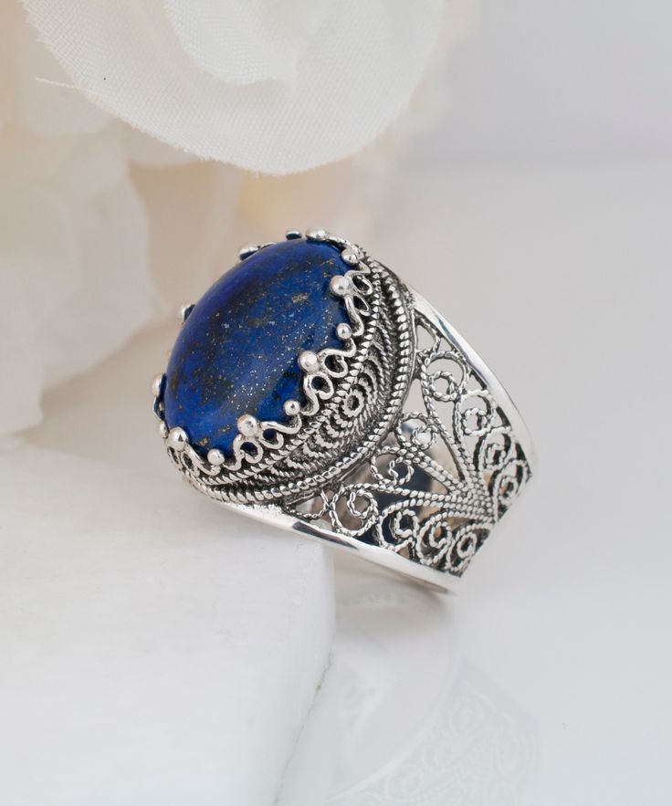 Natural Blue Lapis Lazuli Silver Ring 925 Sterling Silver Genuine Gemstone Artisan Handcrafted Filigree Oval Women Jewelry Handmade Gifts, Boho Silver Ring, Oval Statement Ring, Blue Stone Ring, Gift Boxed for Her Material: 925 Sterling Silver (NICKEL FREE) Gemstone: Lapis Lazuli 13x18 mm, 12.5 ct. FREE, FAST AND TRACKABLE SHIPPING FOR ALL EU COUNTRIES AND USA. COMES WİTH VELVET POUCH AND LUXURY GİFT BOX. The handcrafted design makes a dramatic fashion statement with Lapis Lazuli Gemstone. The amazing detail of our designs are such a pleasure to look at! The beautiful style, stylish luxury jewelry is perfect for wearing at parties, festivals, and everyday life. Comes with a gift pouch and box. Our handmade pieces are the perfect gift for a mom, wife, daughter, friend, lover, relative, etc. Stone Ring Design, Dramatic Fashion, Blue Stone Ring, Lapis Lazuli Ring, Sterling Silver Filigree, Luxury Gift Box, Hand Crafted Gifts, Blue Stone, Handmade Artisan