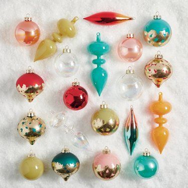 an assortment of christmas ornaments on a white surface