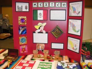 a table with many different items on it and some people in the background looking at them