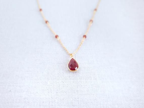 Garnet Pendant - Gold Garnet Necklace - Teardrop Necklace - Birthstone Necklace - Red Drop Necklace - January BirthstoneThe tiny red stone necklace is made of Garnet stone. Garnet is a stone of prosperity and abundance, encouraging gratitude and service to others.Garnet is the birthstone for the month of January and makes a lovely birthday gift.-------------MATERIALThe Garnet stone is in a teardrop 8x12mm setting and is made via hydrothermal process.---------------------------------------------- Red Gemstone Drop Necklace For Gift, Red Drop Necklace For Gift, Red Teardrop Gemstone Drop Necklace, Red Teardrop Gemstone Necklace, Red Briolette Necklaces For Jewelry Making, Red Briolette Beads For Jewelry Making, Real Ruby Necklace, Red Stone Necklace, January Birthstone Necklace