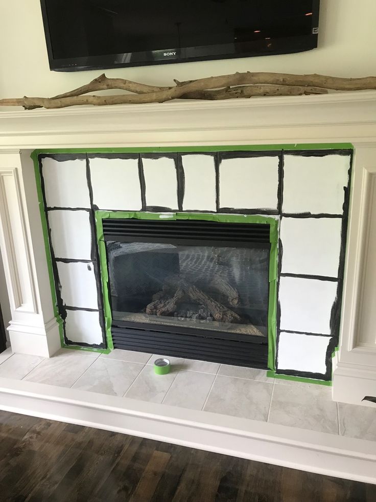 a fireplace with white and green paint on the mantel, next to a flat screen tv mounted above it