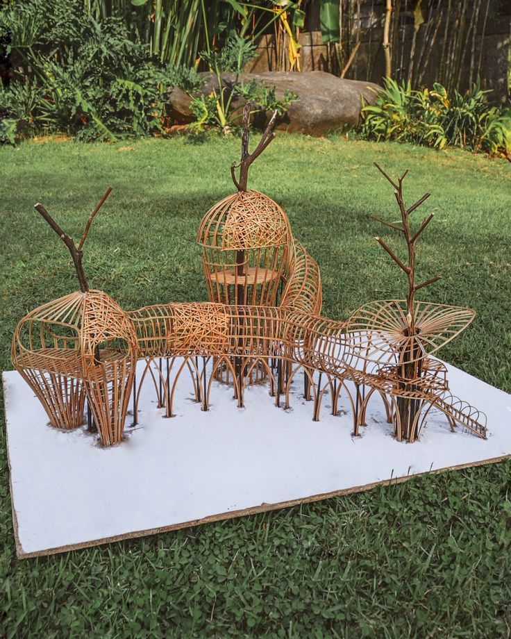 a group of wooden sculptures sitting on top of a grass covered field next to trees