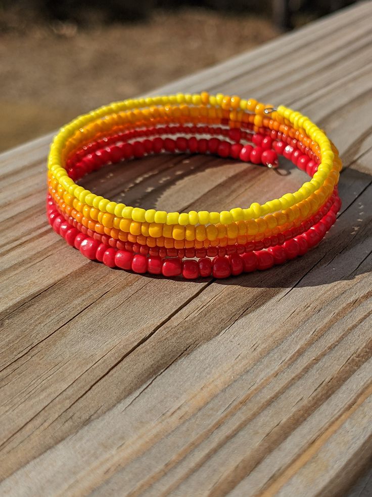 three different colored bracelets sitting on top of a wooden table