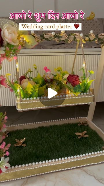 two tiered trays filled with flowers and greenery